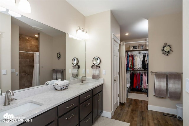 1630 S Corwin Ln, Wasilla, AK 99654 - full bath featuring double vanity, baseboards, wood finished floors, a tile shower, and recessed lighting