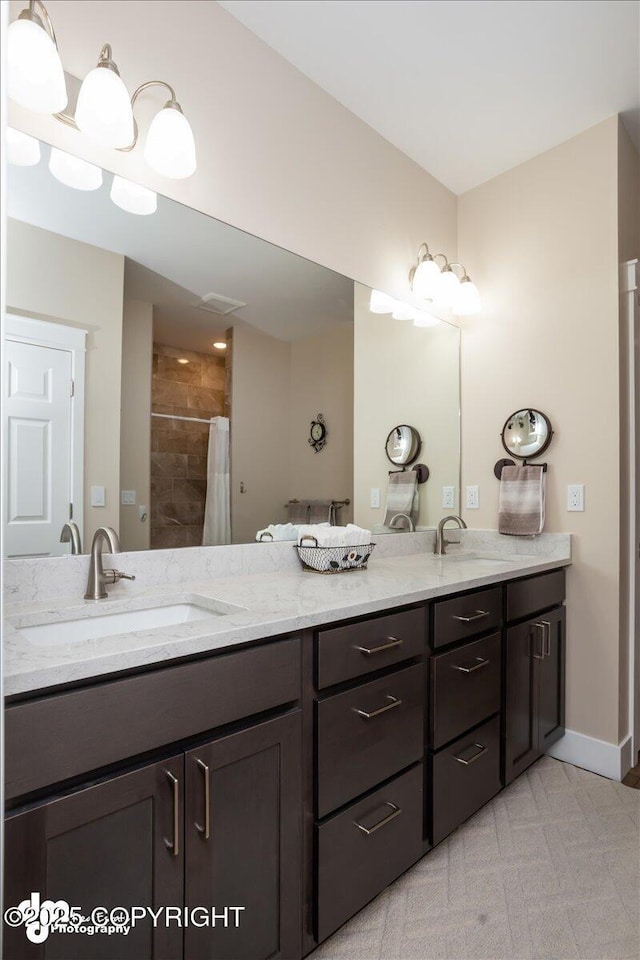 1630 S Corwin Ln, Wasilla, AK 99654 - bathroom featuring double vanity, a tile shower, and baseboards