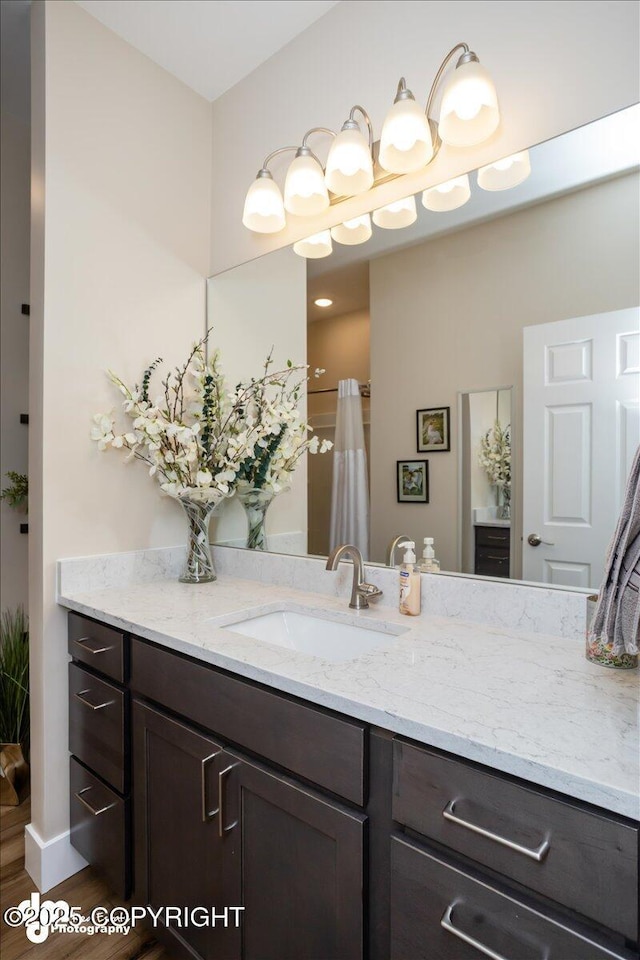 1630 S Corwin Ln, Wasilla, AK 99654 - full bathroom with vanity, wood finished floors, a shower with shower curtain, and baseboards