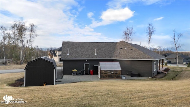 1630 S Corwin Ln, Wasilla, AK 99654 - rear view of house featuring a lawn, an outdoor structure, and a shingled roof