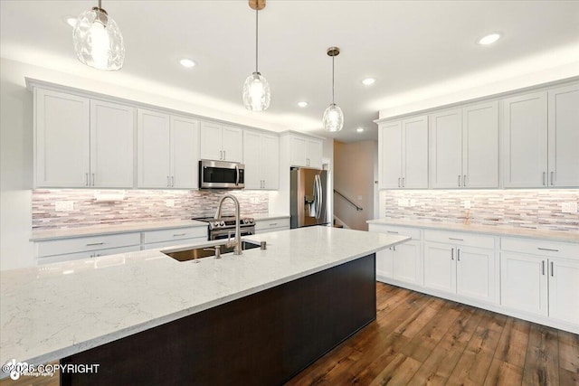1630 S Corwin Ln, Wasilla, AK 99654 - kitchen featuring appliances with stainless steel finishes, backsplash, decorative light fixtures, light stone counters, and recessed lighting