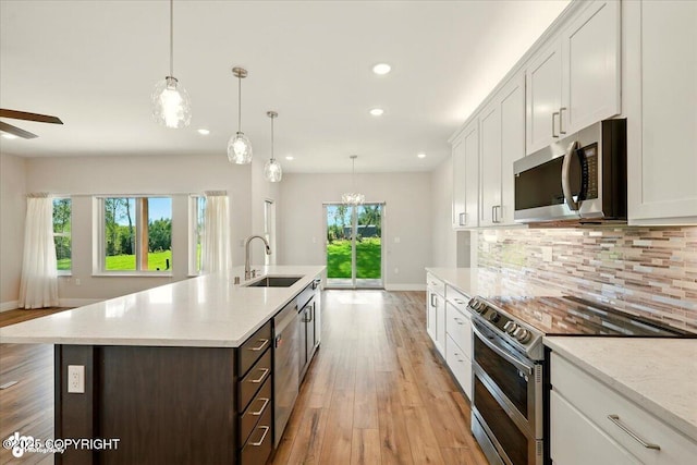 1630 S Corwin Ln, Wasilla, AK 99654 - kitchen featuring stainless steel appliances, light wood-style floors, white cabinets, decorative backsplash, and recessed lighting
