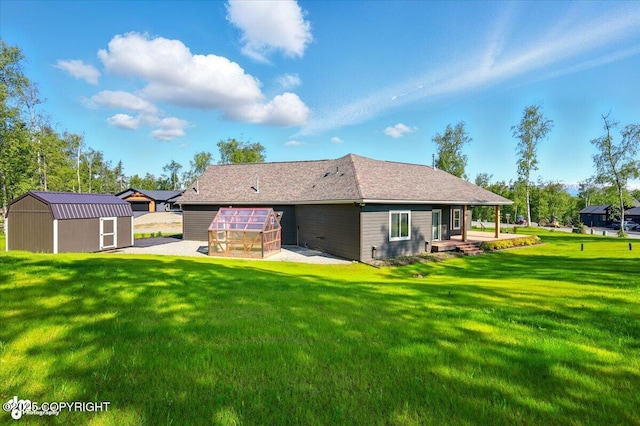 1630 S Corwin Ln, Wasilla, AK 99654 - back of house featuring a greenhouse, an outbuilding, and a yard