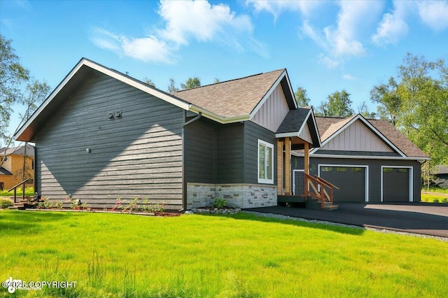 1630 S Corwin Ln, Wasilla, AK 99654 - view of front of home featuring a garage, board and batten siding, a front lawn, roof with shingles, and asphalt driveway