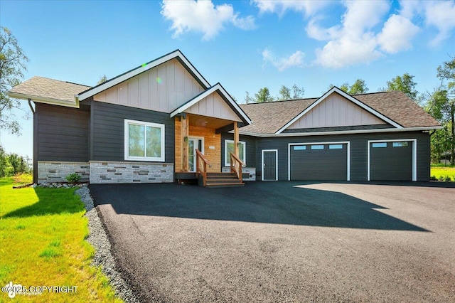 1630 S Corwin Ln, Wasilla, AK 99654 - view of front of property with board and batten siding, asphalt driveway, a garage, and stone siding