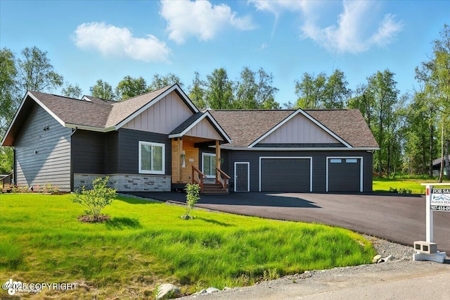 1630 S Corwin Ln, Wasilla, AK 99654 - view of front of home featuring a garage, board and batten siding, a front yard, a shingled roof, and driveway