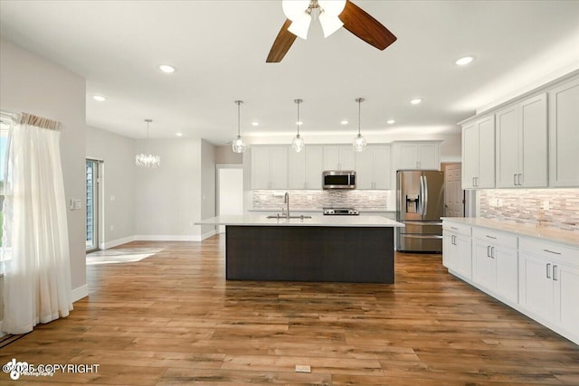 1630 S Corwin Ln, Wasilla, AK 99654 - kitchen featuring stainless steel appliances, recessed lighting, backsplash, light countertops, and a kitchen island with sink