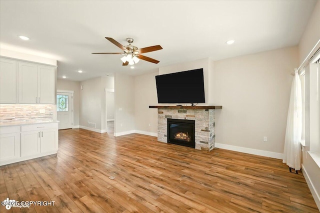 1630 S Corwin Ln, Wasilla, AK 99654 - unfurnished living room featuring light wood finished floors, a ceiling fan, recessed lighting, and a stone fireplace