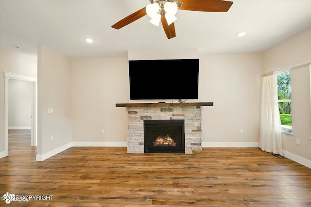 1630 S Corwin Ln, Wasilla, AK 99654 - unfurnished living room featuring ceiling fan, wood finished floors, a stone fireplace, and recessed lighting