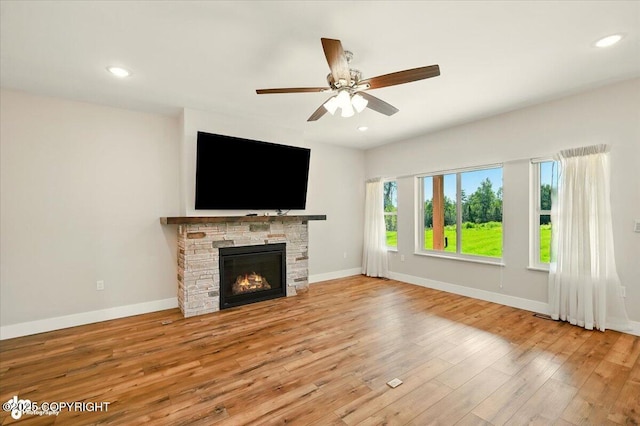 1630 S Corwin Ln, Wasilla, AK 99654 - unfurnished living room with wood finished floors, a ceiling fan, recessed lighting, and a stone fireplace