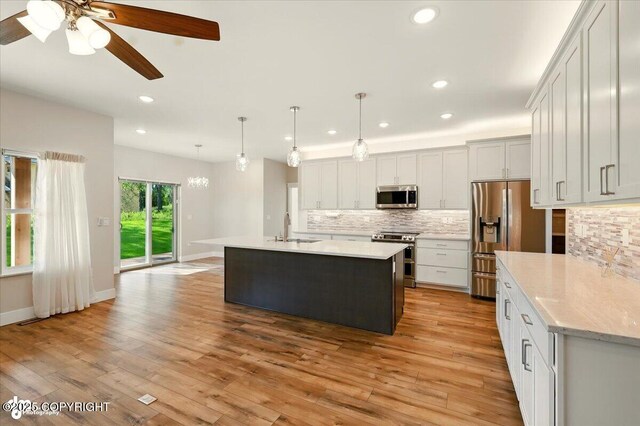 1630 S Corwin Ln, Wasilla, AK 99654 - kitchen with stainless steel appliances, backsplash, light wood finished floors, recessed lighting, and a kitchen island with sink