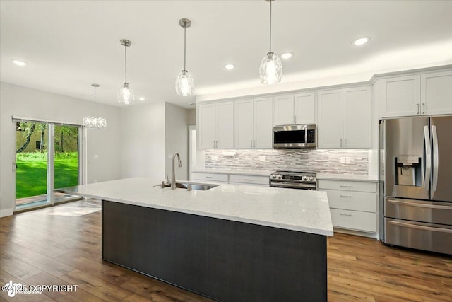 1630 S Corwin Ln, Wasilla, AK 99654 - kitchen with stainless steel appliances, decorative backsplash, recessed lighting, dark wood-type flooring, and a kitchen island with sink