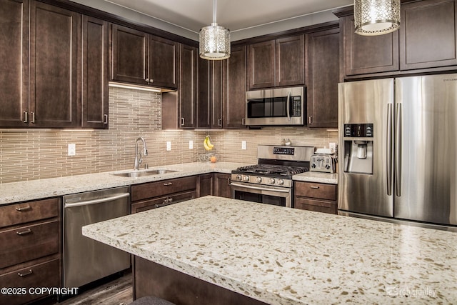 6552 N Michelle Rae St, Wasilla, AK 99654 - kitchen featuring appliances with stainless steel finishes, a sink, dark brown cabinetry, light stone countertops, and tasteful backsplash