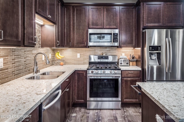 6552 N Michelle Rae St, Wasilla, AK 99654 - kitchen featuring stainless steel appliances, a sink, light stone counters, dark brown cabinetry, and dark wood finished floors