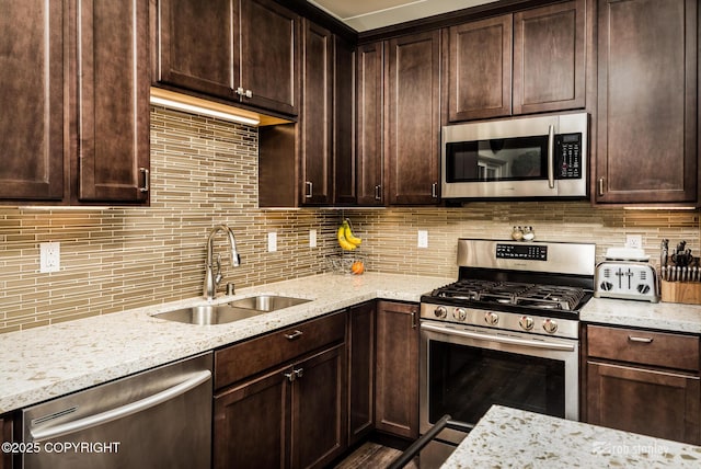6552 N Michelle Rae St, Wasilla, AK 99654 - kitchen with appliances with stainless steel finishes, a sink, dark brown cabinets, and light stone counters