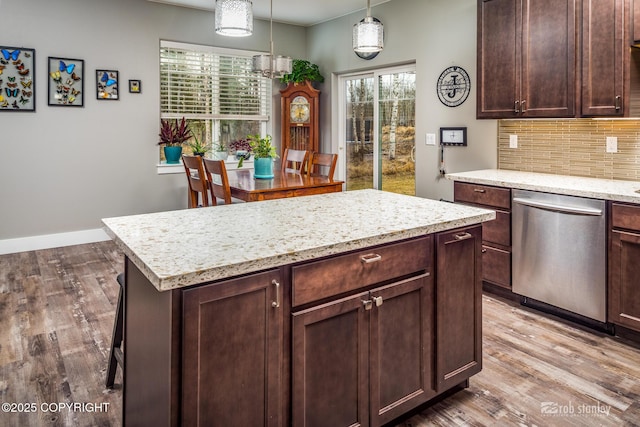 6552 N Michelle Rae St, Wasilla, AK 99654 - kitchen with stainless steel dishwasher, decorative backsplash, wood finished floors, a center island, and light stone countertops