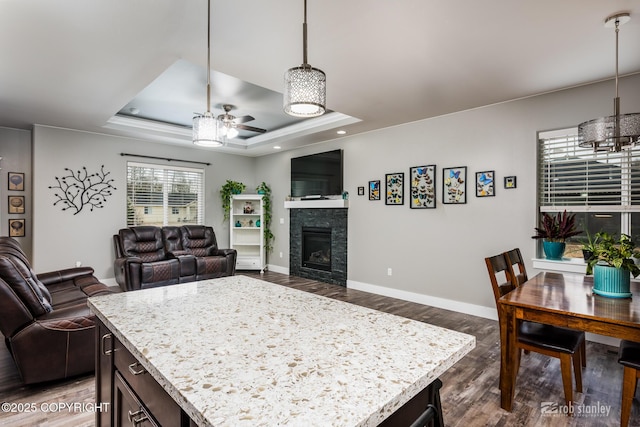 6552 N Michelle Rae St, Wasilla, AK 99654 - kitchen featuring a tray ceiling, ceiling fan, open floor plan, dark wood-style floors, and a fireplace