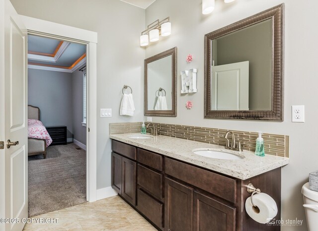 6552 N Michelle Rae St, Wasilla, AK 99654 - ensuite bathroom with double vanity, decorative backsplash, crown molding, and baseboards
