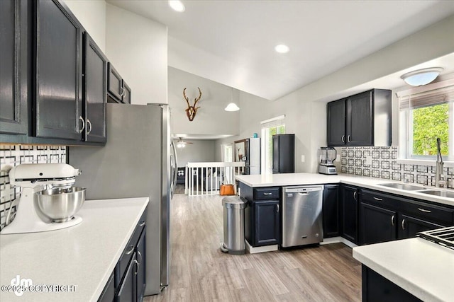 1320 S Felton St, Palmer, AK 99645 - kitchen featuring appliances with stainless steel finishes, a sink, vaulted ceiling, a peninsula, and tasteful backsplash