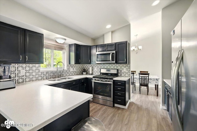 1320 S Felton St, Palmer, AK 99645 - kitchen with stainless steel appliances, a sink, light countertops, light wood finished floors, and a chandelier