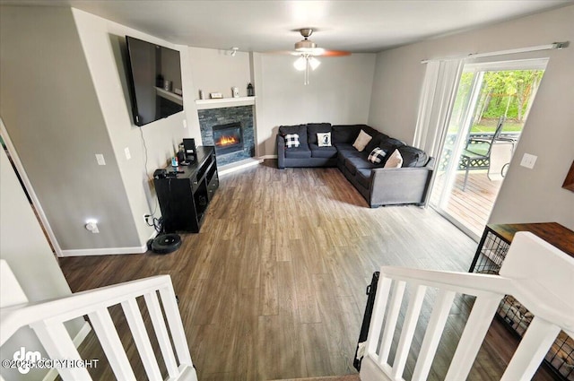 1320 S Felton St, Palmer, AK 99645 - living room featuring wood finished floors, a ceiling fan, a fireplace, and baseboards