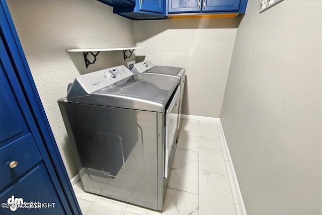 1320 S Felton St, Palmer, AK 99645 - washroom featuring washing machine and dryer, light marble finish floors, cabinet space, and baseboards