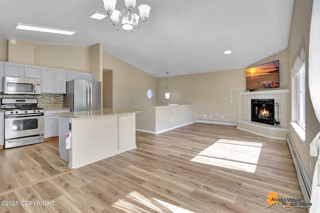 3233 Tayshee Cir, Anchorage, AK 99504 - kitchen with stainless steel appliances, vaulted ceiling, a baseboard heating unit, a baseboard radiator, and plenty of natural light