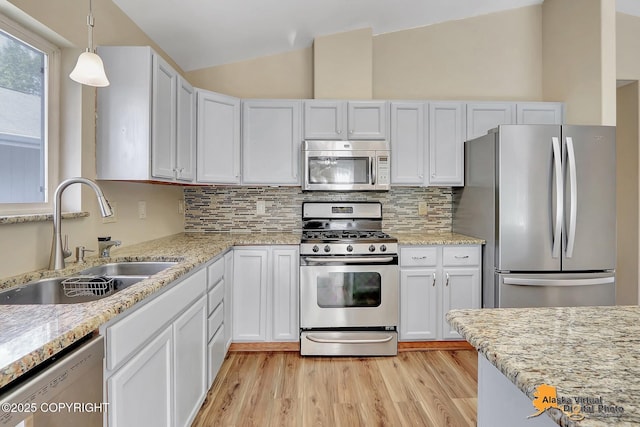 3233 Tayshee Cir, Anchorage, AK 99504 - kitchen featuring stainless steel appliances, a sink, vaulted ceiling, light wood finished floors, and decorative backsplash