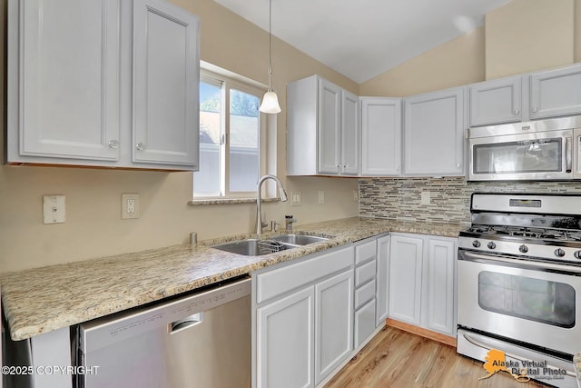 3233 Tayshee Cir, Anchorage, AK 99504 - kitchen with appliances with stainless steel finishes, a sink, lofted ceiling, light wood-style flooring, and white cabinetry