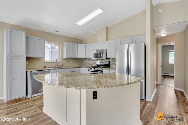 3233 Tayshee Cir, Anchorage, AK 99504 - kitchen with stainless steel appliances, lofted ceiling, a sink, light wood-style floors, and a center island