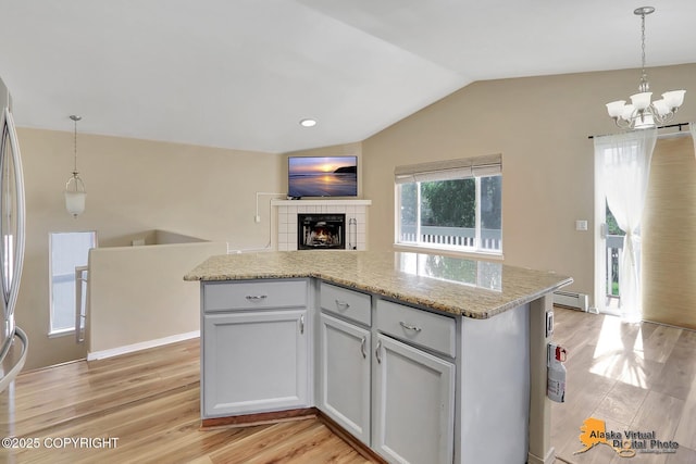 3233 Tayshee Cir, Anchorage, AK 99504 - kitchen with vaulted ceiling, a chandelier, a baseboard radiator, light wood finished floors, and decorative light fixtures