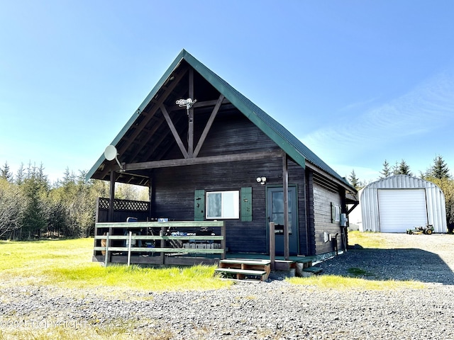 31795 Whiskey Gulch St, Anchor Point, AK 99556 - view of front of home featuring an outbuilding, gravel driveway, and covered porch