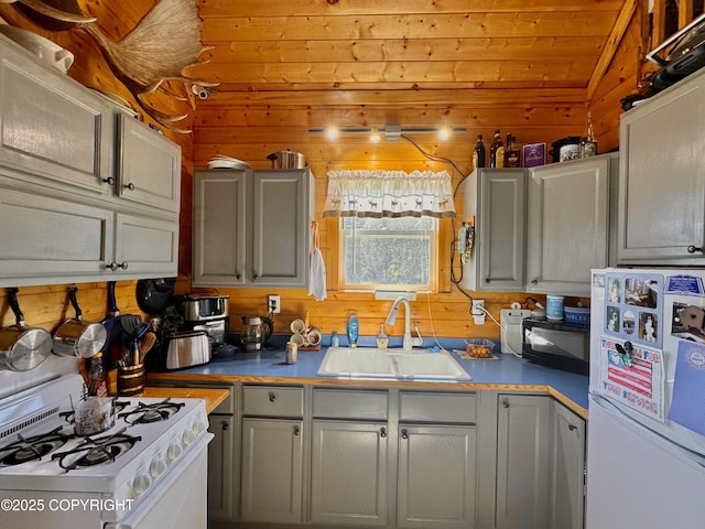 31795 Whiskey Gulch St, Anchor Point, AK 99556 - kitchen with white appliances, a sink, wood walls, gray cabinetry, and light countertops