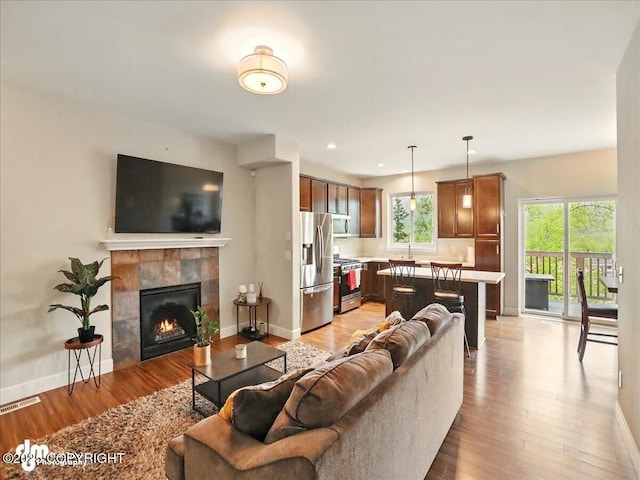 20182 Eagles Nest Ct # 5B, Eagle River, AK 99577 - living room with light wood finished floors, baseboards, a tile fireplace, and recessed lighting