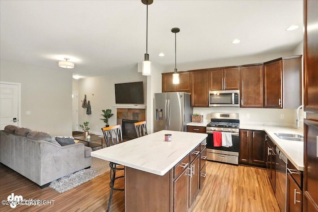 20182 Eagles Nest Ct # 5B, Eagle River, AK 99577 - kitchen featuring stainless steel appliances, open floor plan, light wood-type flooring, a kitchen breakfast bar, and a center island