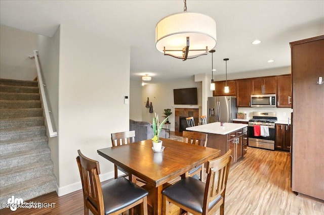 20182 Eagles Nest Ct # 5B, Eagle River, AK 99577 - dining room featuring stairway, light wood finished floors, recessed lighting, a tile fireplace, and baseboards