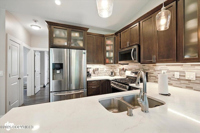 1521 N Kerry Ln, Wasilla, AK 99654 - kitchen featuring appliances with stainless steel finishes, dark brown cabinets, backsplash, hanging light fixtures, and glass insert cabinets