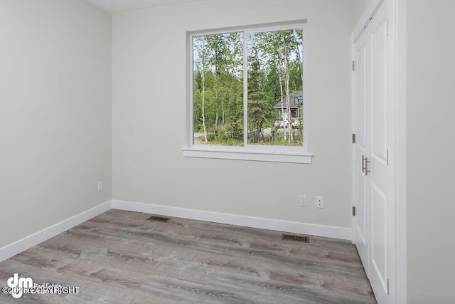 1521 N Kerry Ln, Wasilla, AK 99654 - unfurnished bedroom featuring multiple windows, wood finished floors, and a closet
