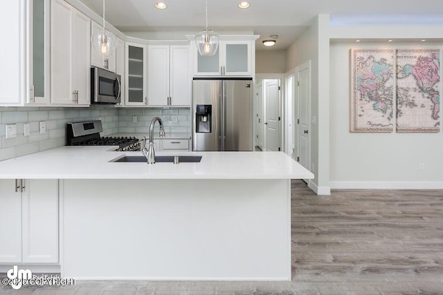 1521 N Kerry Ln, Wasilla, AK 99654 - kitchen featuring stainless steel appliances, a peninsula, tasteful backsplash, decorative light fixtures, and recessed lighting