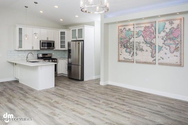 1521 N Kerry Ln, Wasilla, AK 99654 - kitchen featuring appliances with stainless steel finishes, a peninsula, light countertops, a chandelier, and light wood finished floors
