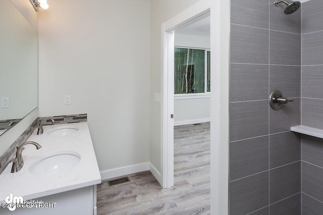 1521 N Kerry Ln, Wasilla, AK 99654 - full bath featuring double vanity, a tile shower, and wood finished floors