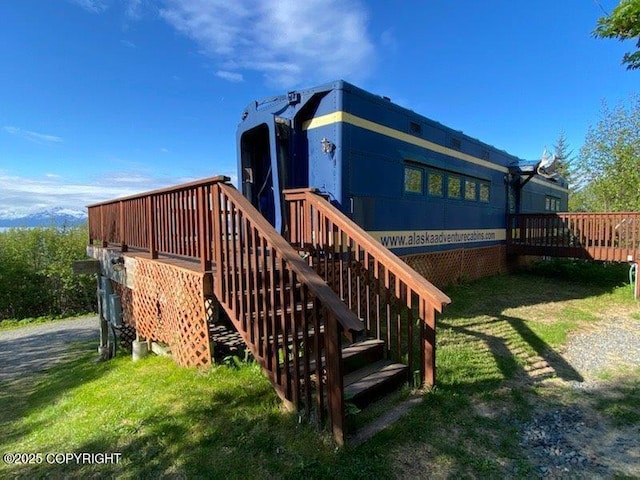 2525 Sterling Hwy, Homer, AK 99603 - back of property featuring stairway, a deck, and a lawn