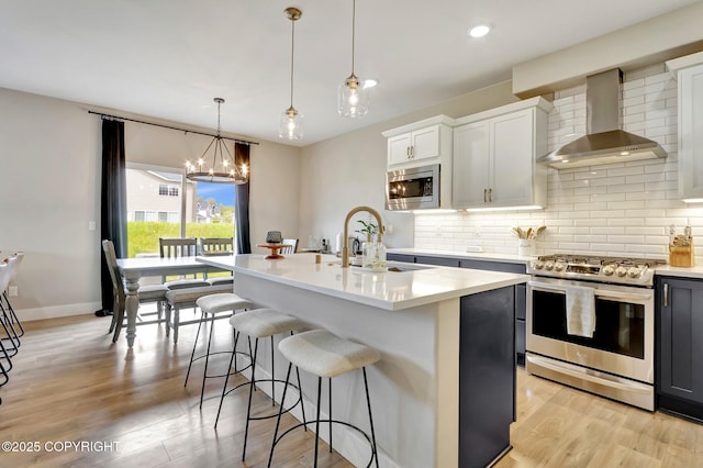 8784 Dry Creek Loop # 40A, Anchorage, AK 99502 - kitchen with appliances with stainless steel finishes, wall chimney exhaust hood, decorative backsplash, light countertops, and a breakfast bar area