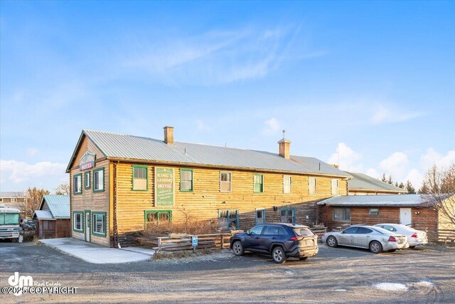 147 E Pioneer Ave, Homer, AK 99603 - view of front of home with a chimney, metal roof, and uncovered parking
