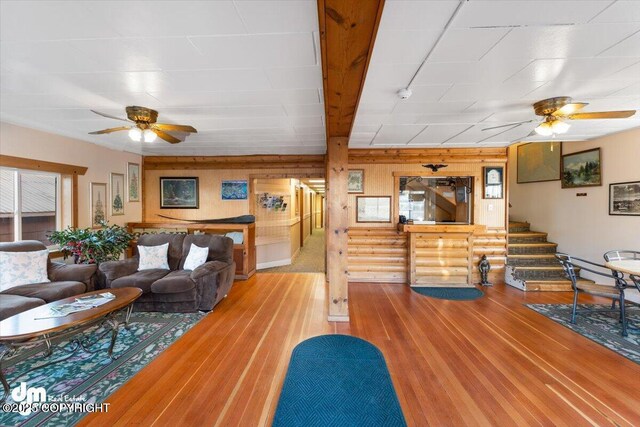 147 E Pioneer Ave, Homer, AK 99603 - living room featuring a ceiling fan, wood finished floors, stairway, and wood walls