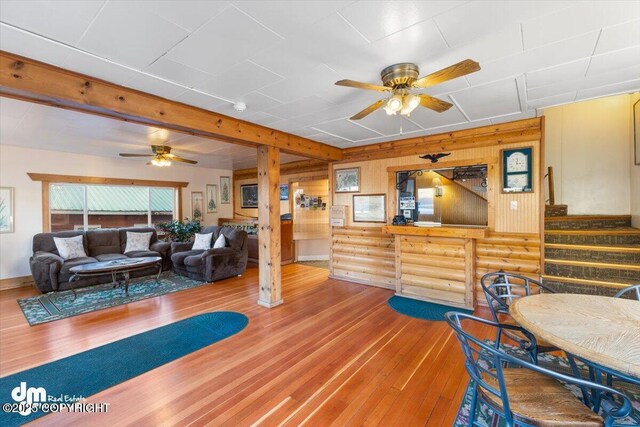 147 E Pioneer Ave, Homer, AK 99603 - dining room with ceiling fan, hardwood / wood-style flooring, log walls, and stairs