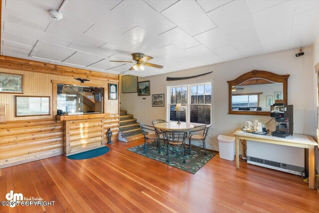 147 E Pioneer Ave, Homer, AK 99603 - dining room with wood-type flooring, a ceiling fan, stairs, and log walls