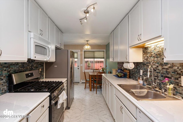 1920 E 56th Ave, Anchorage, AK 99507 - kitchen with appliances with stainless steel finishes, a sink, light marble finish flooring, white cabinetry, and backsplash