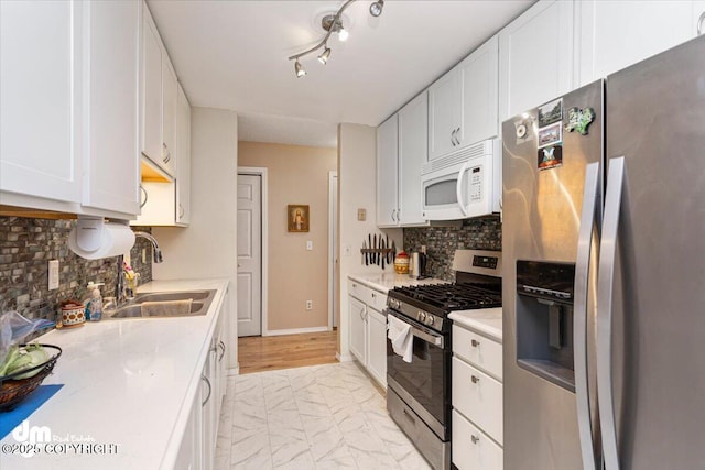 1920 E 56th Ave, Anchorage, AK 99507 - kitchen featuring stainless steel appliances, a sink, light marble finish floors, and white cabinetry