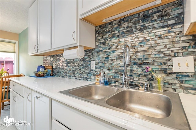 1920 E 56th Ave, Anchorage, AK 99507 - kitchen featuring a sink, light countertops, tasteful backsplash, and white cabinets